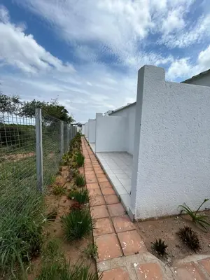 a fence and a brick walkway next to a wall at Riverview Pool Resort and Lodge in Moletlane