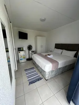 a bedroom with a large bed and a television at Riverview Pool Resort and Lodge in Moletlane