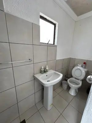 a white bathroom with a toilet and a sink at Riverview Pool Resort and Lodge in Moletlane