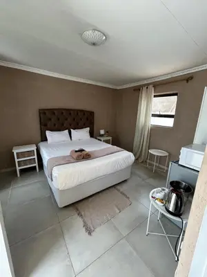 a bedroom with a large white bed in a room at Riverview Pool Resort and Lodge in Moletlane