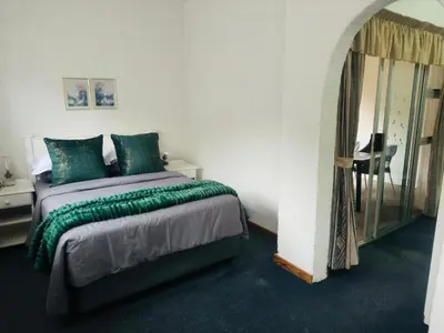 a bedroom with a large bed and a mirror at Busa House One bedroom Unit in White River