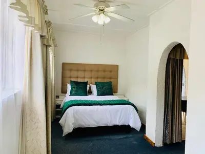 a bedroom with a bed and a ceiling fan at Busa House One bedroom Unit in White River