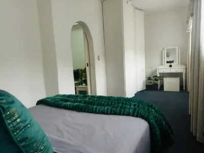 a bedroom with a green blanket on a bed at Busa House One bedroom Unit in White River
