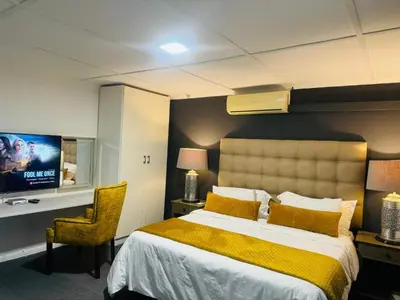 a hotel room with a bed and a tv at Busa House Self-Catering Unit in White River