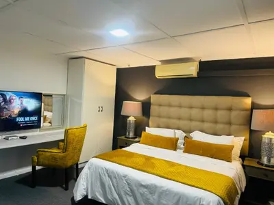 a hotel room with a bed and a tv at Busa House Self-Catering Unit in White River