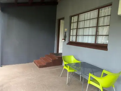 a room with two chairs and a table and a window at Busa House Self-Catering Unit in White River