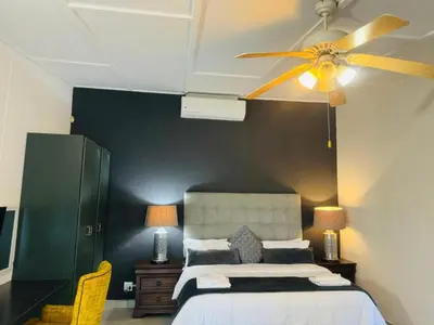 a bedroom with a bed and a ceiling fan at Busa House Self-Catering Guest House in White River