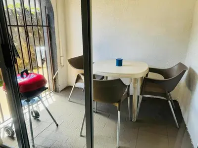a small table and chairs in a room with a window at Busa House - Triple Room in White River