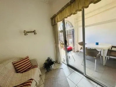 a room with a bed and a table and a window at Busa House - Triple Room in White River