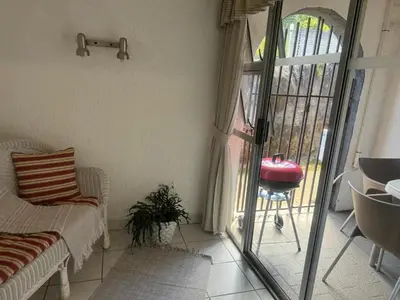 a living room with a sliding glass door to a patio at Busa House - Triple Room in White River