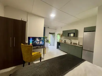 a kitchen with a desk with a tv and a chair at Busa House Self-Catering guest house Caravan Park in White River
