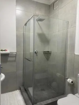 a shower with a glass door in a bathroom at Busa House Self-Catering guest house Caravan Park in White River