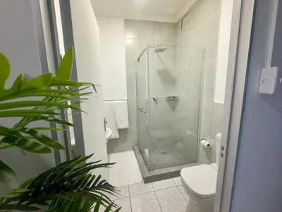 a bathroom with a shower stall and a toilet at Busa House Self-Catering guest house Caravan Park in White River