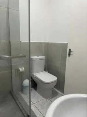 a bathroom with a toilet and a shower stall at Busa House Self-Catering guest house Caravan Park in White River