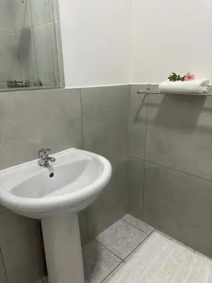 a bathroom with a white sink and a mirror at Busa House Self-Catering guest house Caravan Park in White River