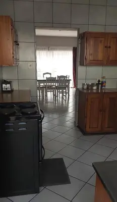 a kitchen with a stove and a dining room at Brits Contractors Accommodation in Brits