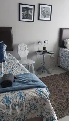 a bedroom with a bed and a table in it at Brits Contractors Accommodation in Brits