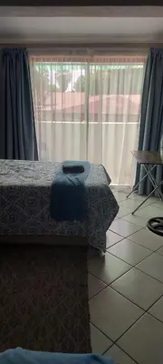 a bedroom with a bed and a large window at Brits Contractors Accommodation in Brits