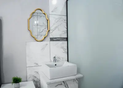 a white bathroom with a sink and a mirror at Plein On Suid Guesthouse in Polokwane