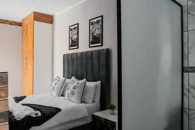 a bedroom with a bed and a mirror at Plein On Suid Guesthouse in Polokwane