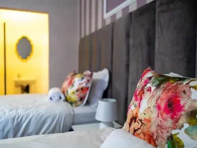 a bedroom with a bed and a couch and a mirror at Plein On Suid Guesthouse in Polokwane