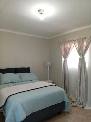 a bedroom with a large bed and a window at Zone 4 Motel and spa in Polokwane