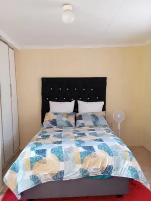 a bedroom with a bed with a colorful comforter at Zone 4 Motel and spa in Polokwane