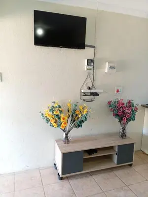 a room with two vases of flowers on a table at Zone 4 Motel and spa in Polokwane