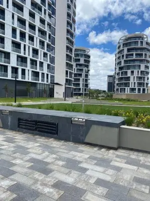 a bench in front of two tall buildings at Oku Luxury apartment, Ellipse, Waterfall in Midrand