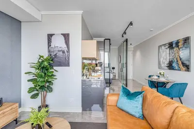 a living room with a couch and a table at Oku Luxury apartment, Ellipse, Waterfall in Midrand
