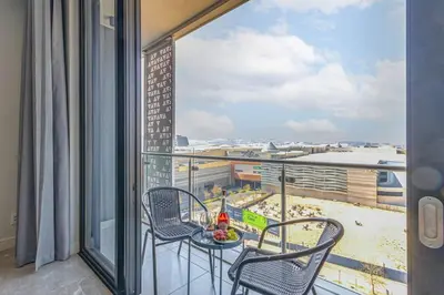 a balcony with a table and chairs and a view at Oku Luxury apartment, Ellipse, Waterfall in Midrand