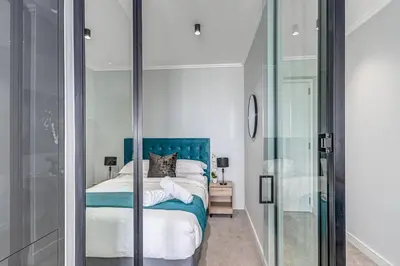 a bedroom with a bed and a glass shower at Oku Luxury apartment, Ellipse, Waterfall in Midrand