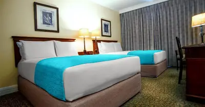 a hotel room with two beds and a window at The Ridge Hotel in Witbank