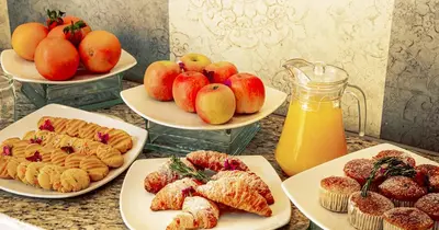 a table topped with plates of pastries and fruit at The Ridge Hotel in Witbank