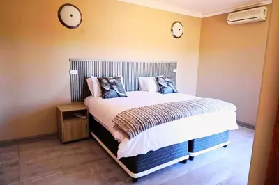 a bedroom with a bed with two clocks on the wall at Zebula Bush Lodge 47 in Moheme