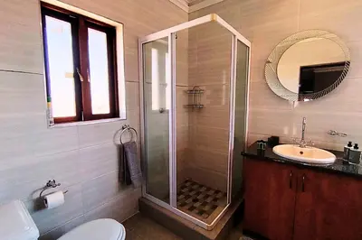a bathroom with a shower and a toilet and a sink at Zebula Bush Lodge 47 in Moheme