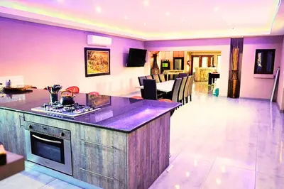 a kitchen and living room with purple walls at Zebula Bush Lodge 47 in Moheme