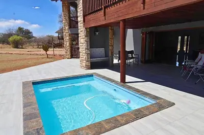 a swimming pool on a patio with a house at Zebula Bush Lodge 47 in Moheme