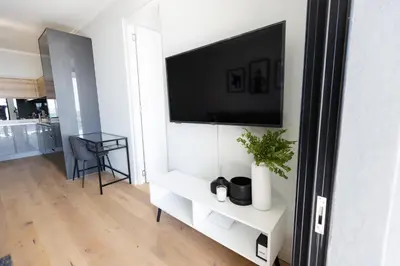 a living room with a flat screen tv on a wall at City Nest - Heart of Waterfall in Midrand