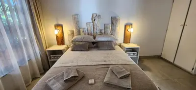 a large bed in a room with two lamps at The Big Tree selfcatering accommodation in White River