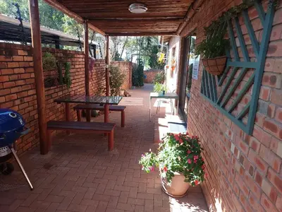 a patio with a table and benches in a brick wall at The Big Tree selfcatering accommodation in White River