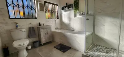 a bathroom with a toilet and a shower and a sink at The Big Tree selfcatering accommodation in White River