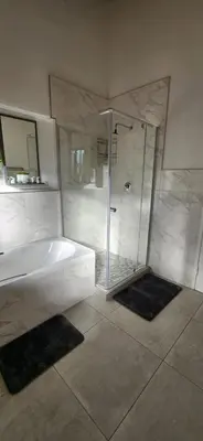 a bathroom with a shower and a white tub at The Big Tree selfcatering accommodation in White River