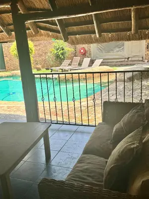 a living room with a couch and a swimming pool at Khaya Africa Guesthouse in Midrand