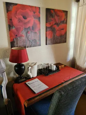 a table with a red table cloth and a lamp at Khaya Africa Guesthouse in Midrand