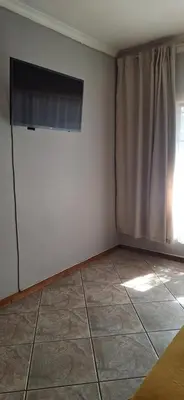 a room with a white wall and a window at Sandgrouse Guesthouse in Centurion