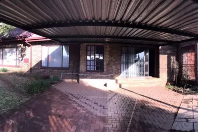 a brick house with awning on a brick patio at Sandgrouse Guesthouse in Centurion