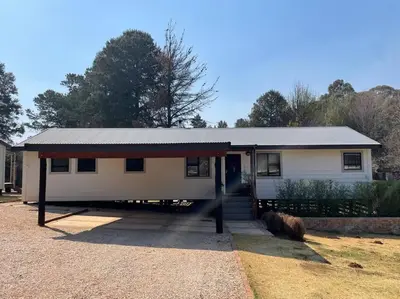 a small white house with a porch at Idlewood Unit 1 in Dullstroom