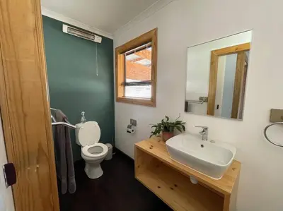 a bathroom with a toilet and a sink and a mirror at Idlewood Unit 1 in Dullstroom