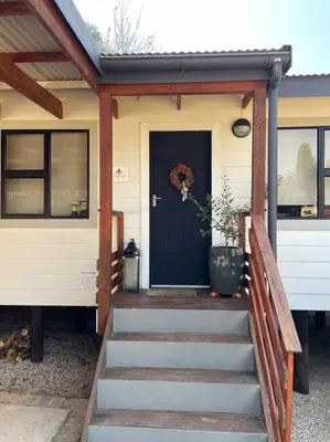 a house with a staircase leading to a black door at Idlewood Unit 1 in Dullstroom